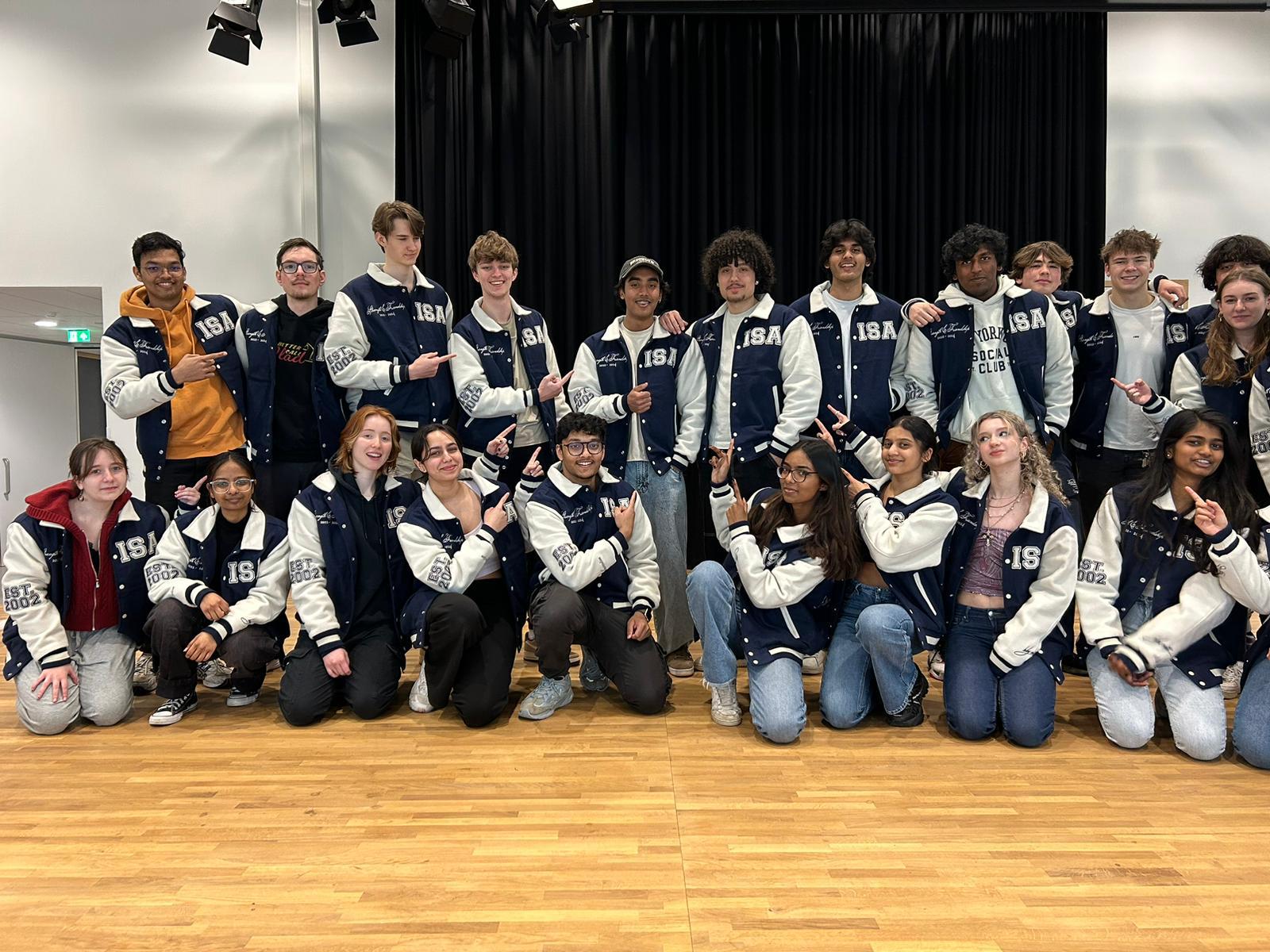 ISA Class of 2024 — full group wearing varsity jackets on delivery day